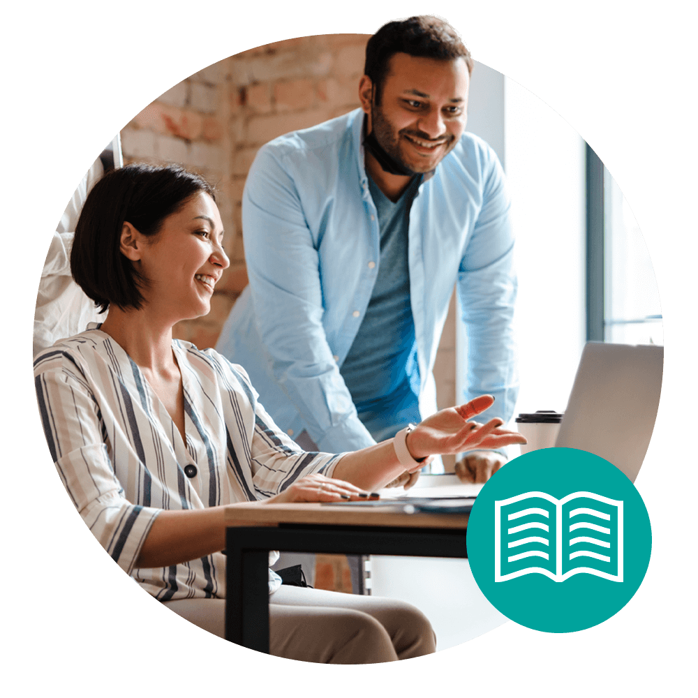 two people sitting at laptop talking