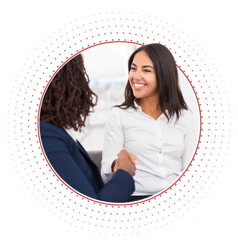 Two people shaking hands and smiling, in a business environment