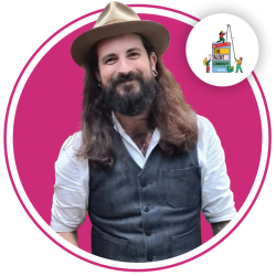 photo of Sean smiling at the camera, dressed smartly and wearing a hat